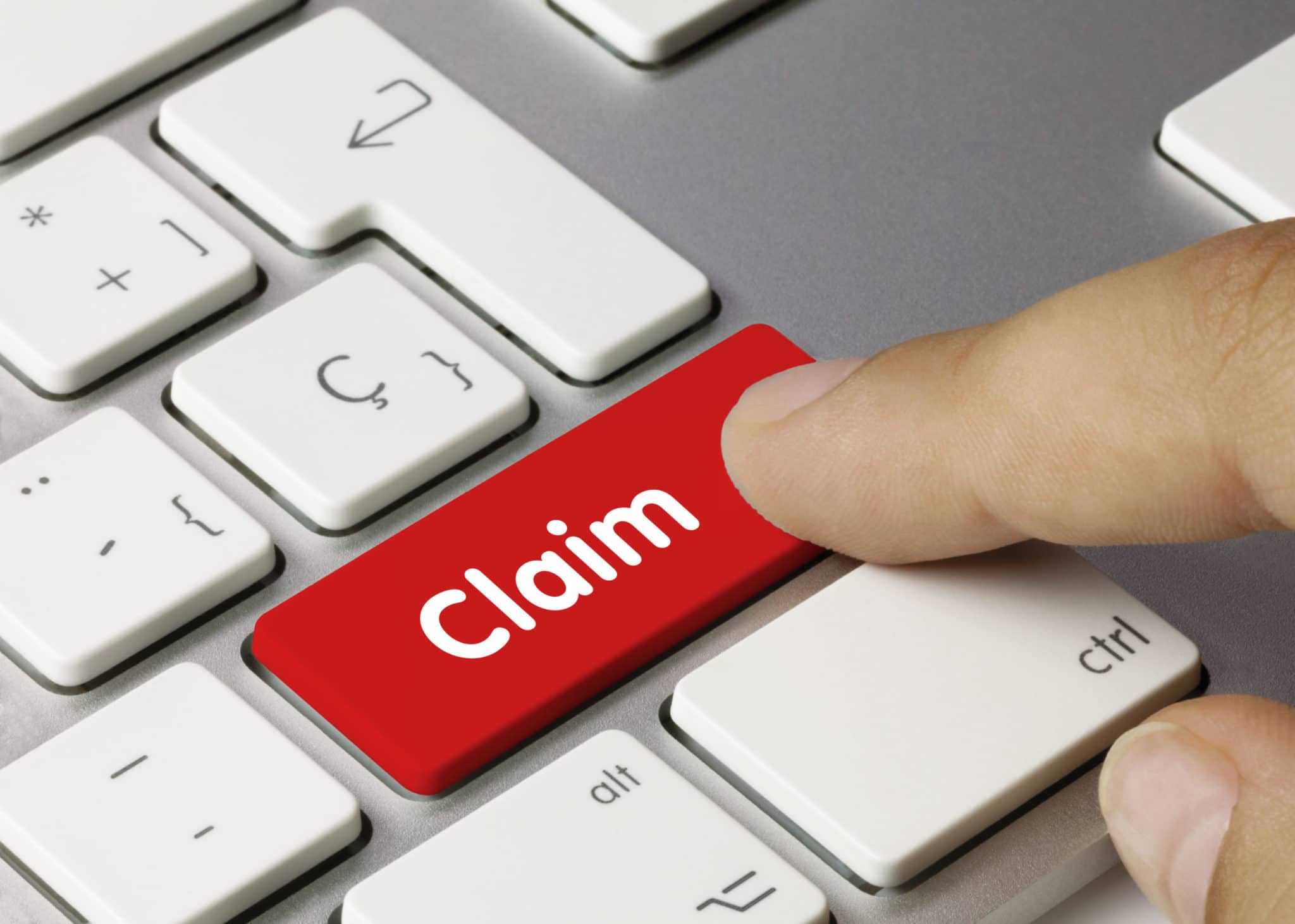 hand hitting a button on computer that says claim