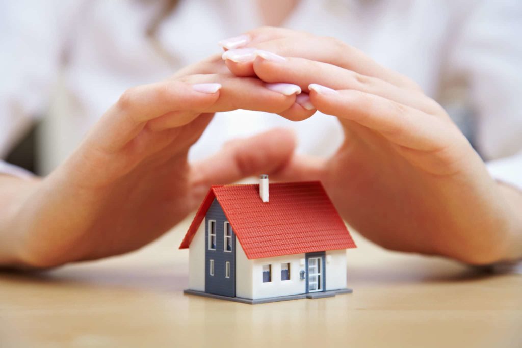 hands over small house, signifying protectio