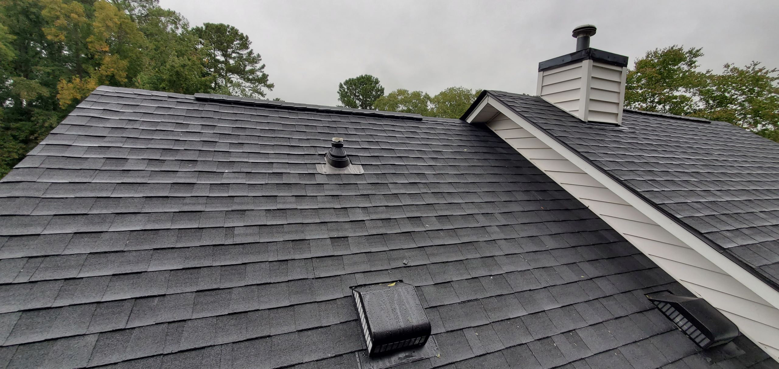 A newly installed asphalt shingle roof showcasing the benefits of a new roof with its pristine condition and optimal protection against weather elements.